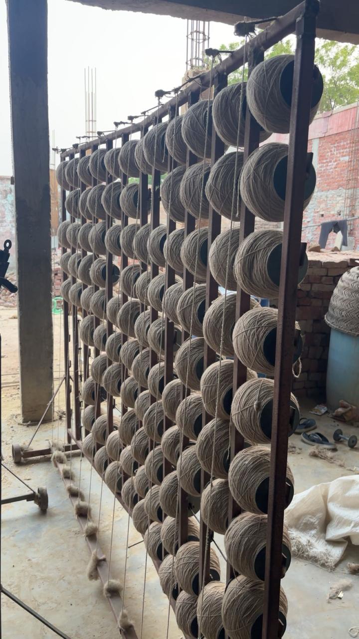 Rows of yarn bobbins on a rack ready for weaving